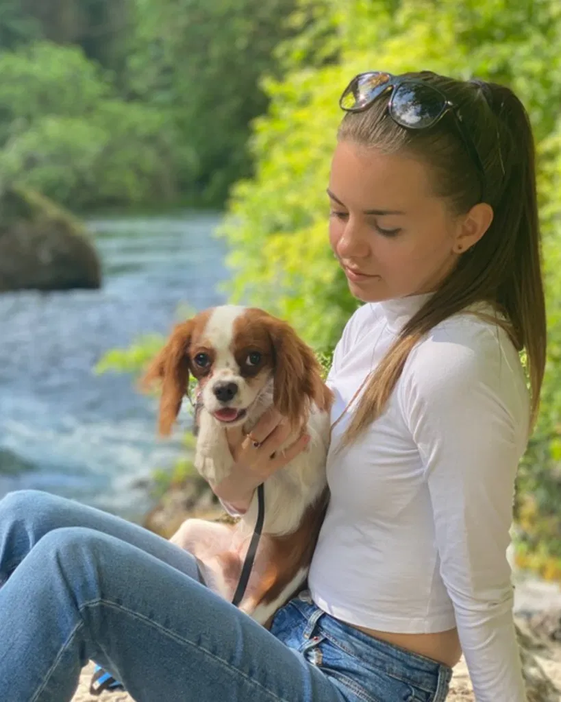 Anastasia tenant un chien dans ses bras et le regardant