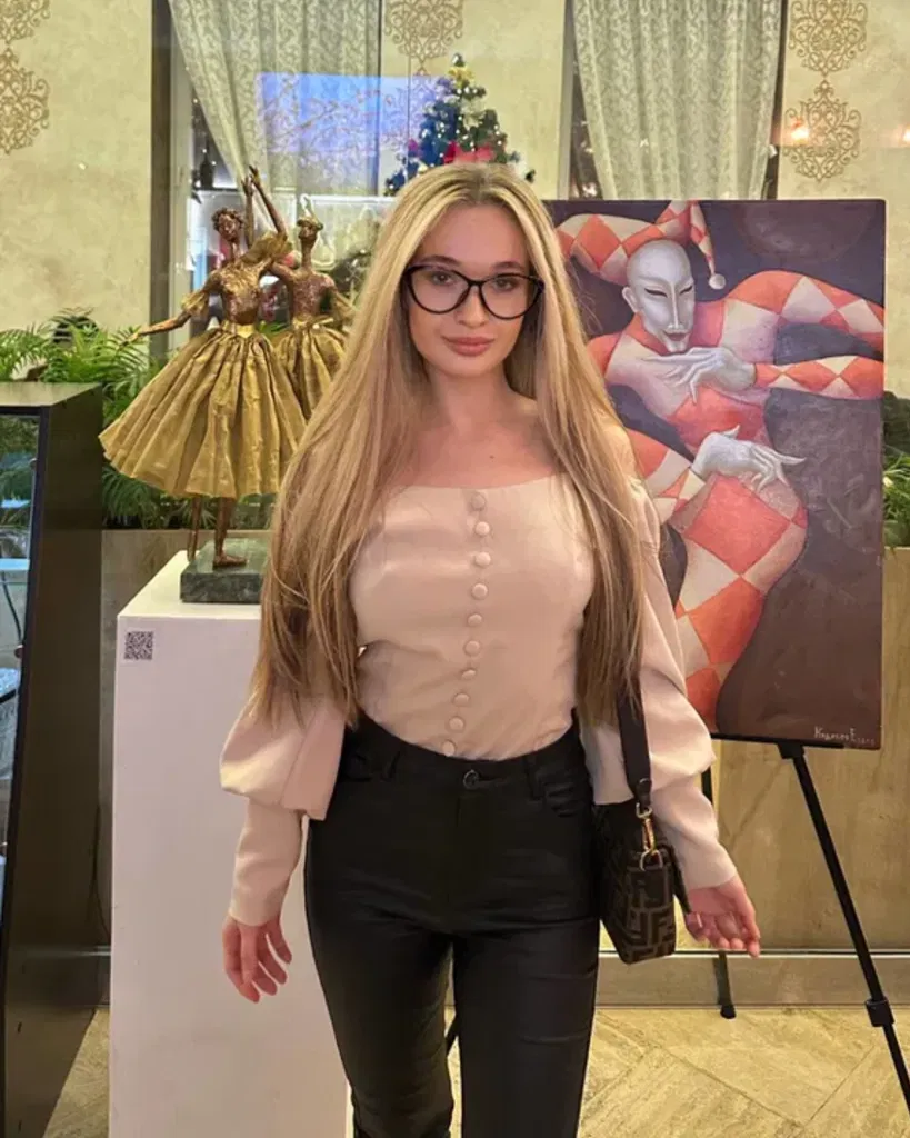 Inna portant des lunettes, avec un fond de tableau et de figurine