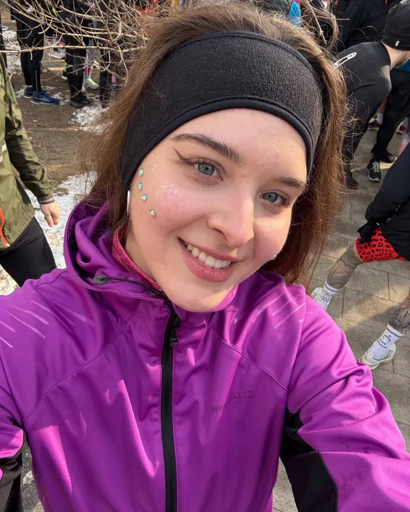 Photo d’Olga en gros plan avec un sourire sur le visage, portant une veste violette
