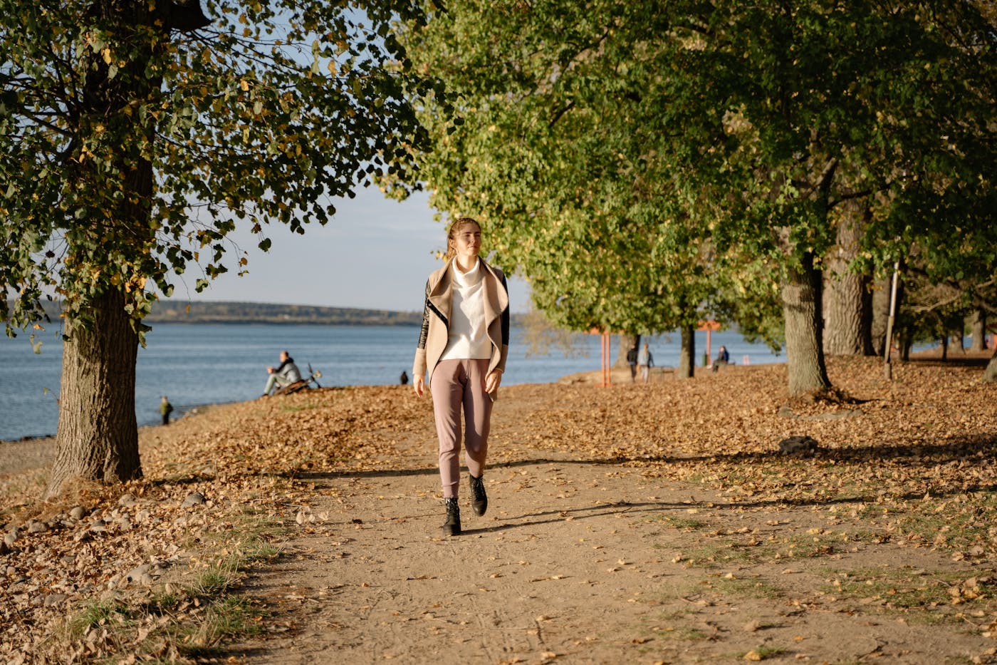 Femme slave marchant dans une allée d'automne, illustrant la sérénité d'un parcours budgétisé et maîtrisé